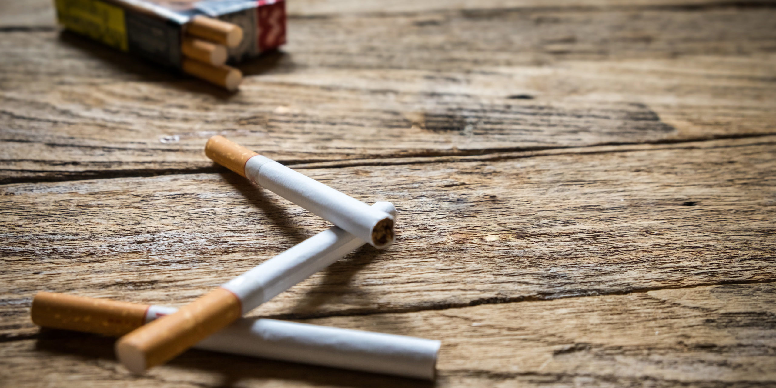 Tobacco in the cigarette, lying on a wooden table